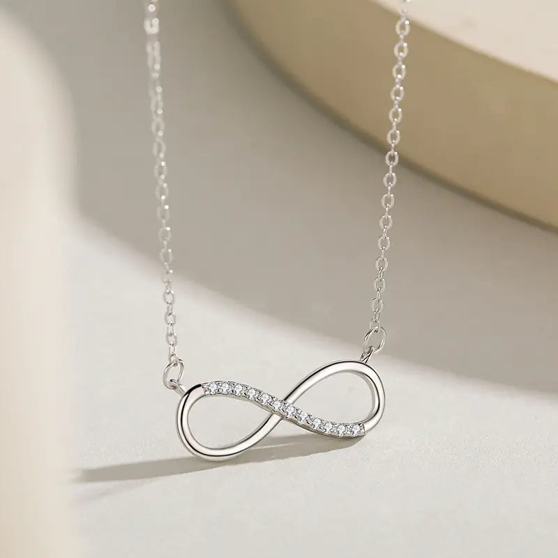 Infinity Bond Necklace on a light cream background